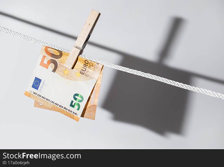 Euro banknote is hung on a rope with clothespin. Concept of the money laundering.