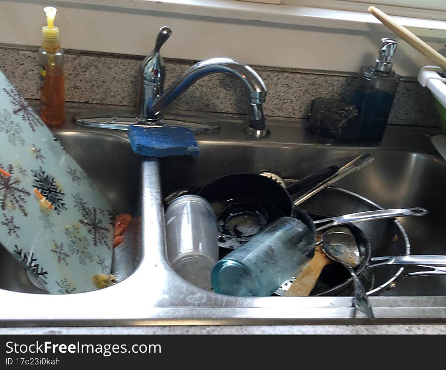 Housekeeper duties, sink full of dirty unwashed dishes, cups, plates, silverware, serving utensitls, pans, pots,  double sink,. Housekeeper duties, sink full of dirty unwashed dishes, cups, plates, silverware, serving utensitls, pans, pots,  double sink,