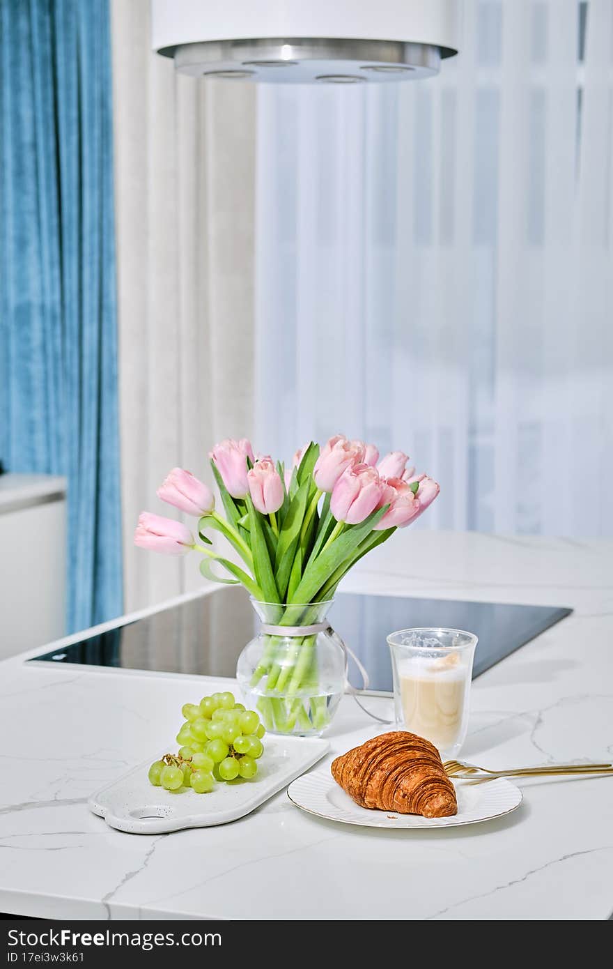 Healthy breakfast on kitchen table - grape, croissant and cappuccino