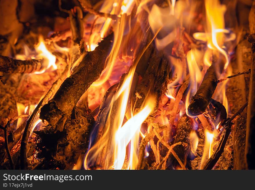 Bright flame of a burning fire in the dark.