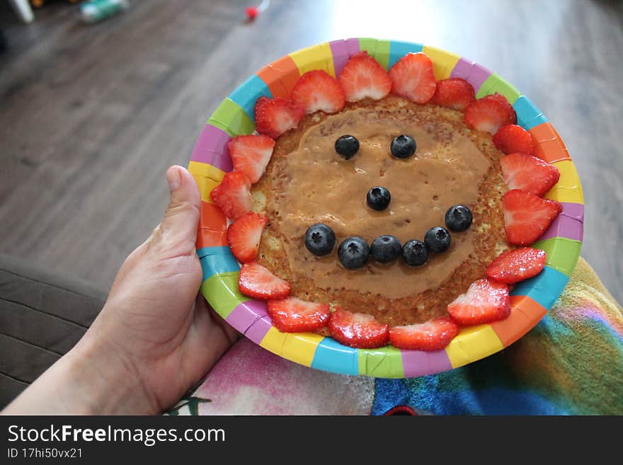 A Smiling Face Made Of Pancakes With Strawberries And Blueberries