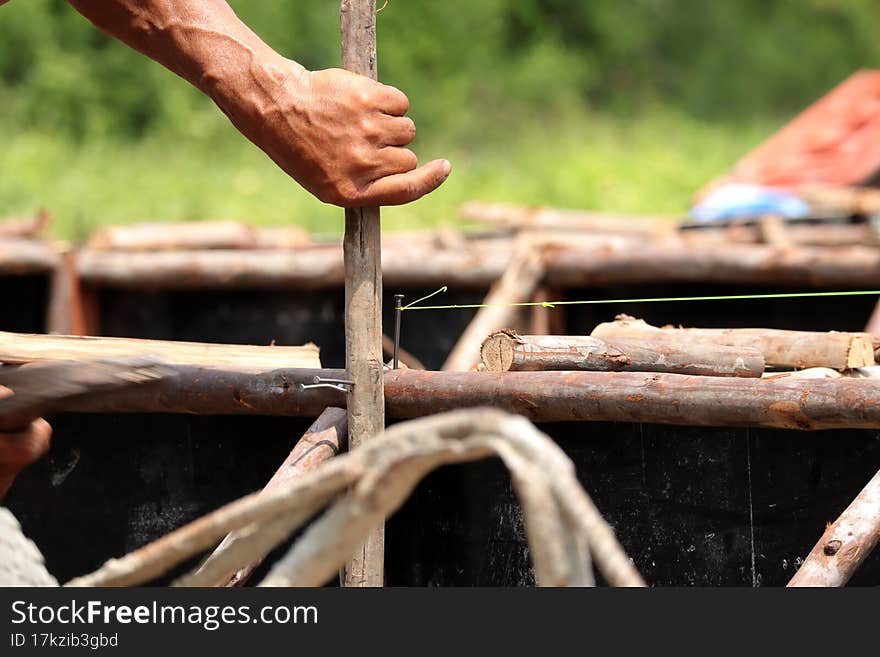 Hands of man working in construction site nailing in the wood with a hammer.Construction concept.