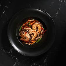 Funchoza With Shrimp And Vegetables On A Black Background, Top View, Copy Space. Glass Noodles, Asian Food. Stock Image