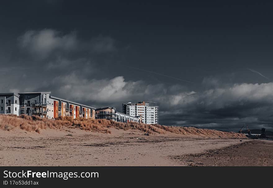 Dark ominous skies over beach and sea front.