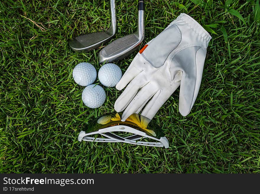 Golf equipment on green grass, ball, glove, tee and golf-club driver, golf gear and equipment on flat lay top view.