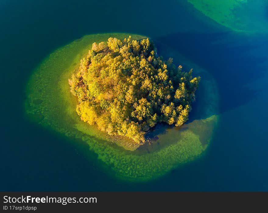 Top view of a small green island in the blue lake, Lithuania