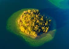 Top View Of A Small Green Island In The Blue Lake Stock Photography