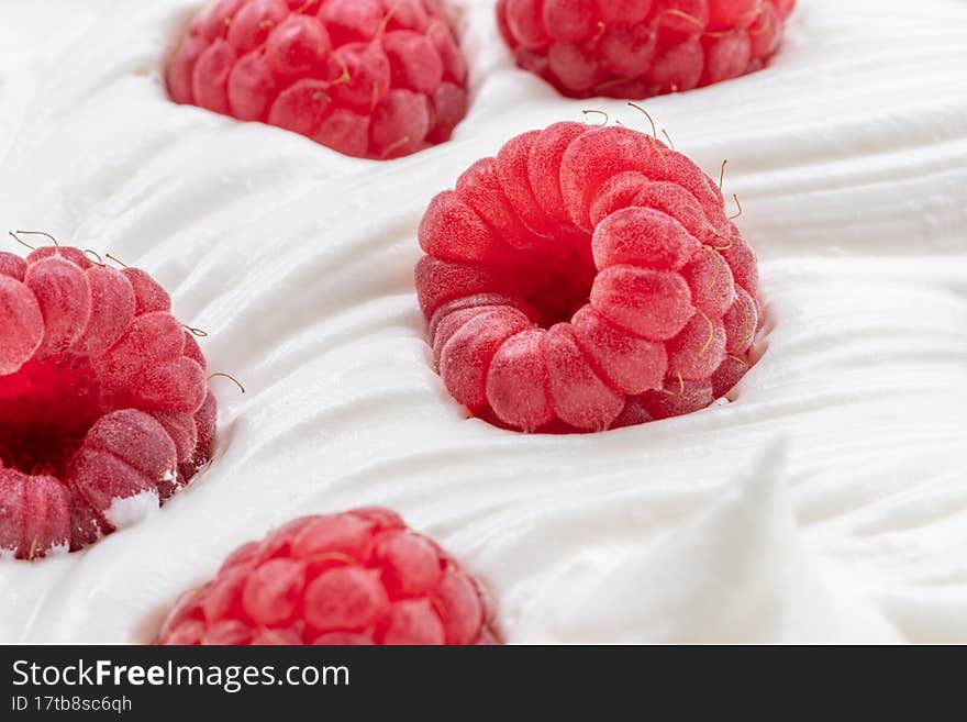 Fresh raspberries in the yoghurt or cream. Top view.