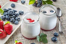 Two Glass Containers With Plain Yoghurt And Berries On The Table. Light Summer Mood Stock Image