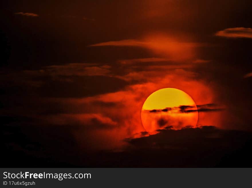 The sun at sunset among the clouds in the sky. The sun at sunset among the clouds in the sky