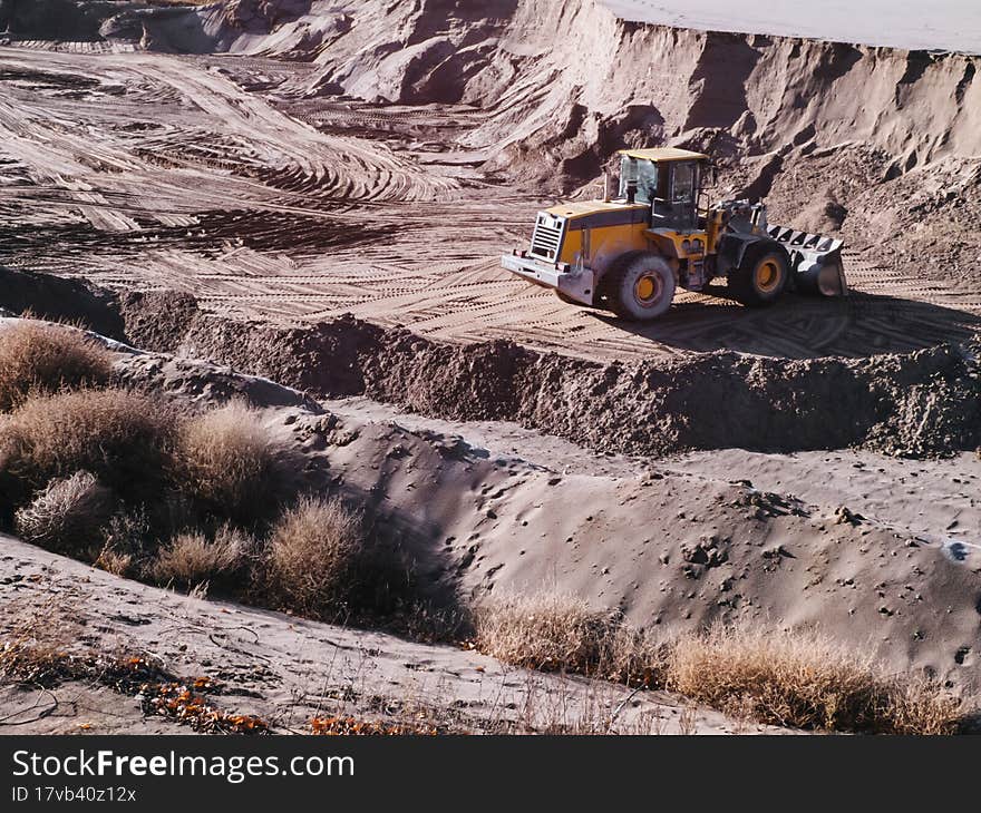 Tractor loader in an opencast sand mine.