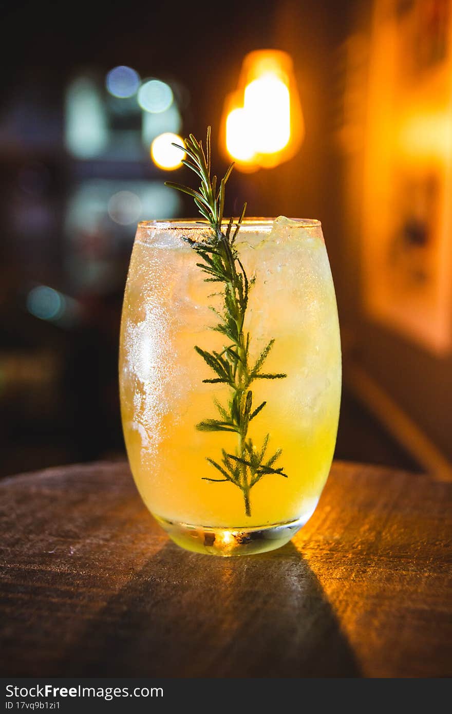 A big Glass with lemon and soda, ice and lemon slices with green plants behind it sesame. A big Glass with lemon and soda, ice and lemon slices with green plants behind it sesame