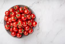Plate With Cherry Tomatoes On White Marble Background Royalty Free Stock Photo