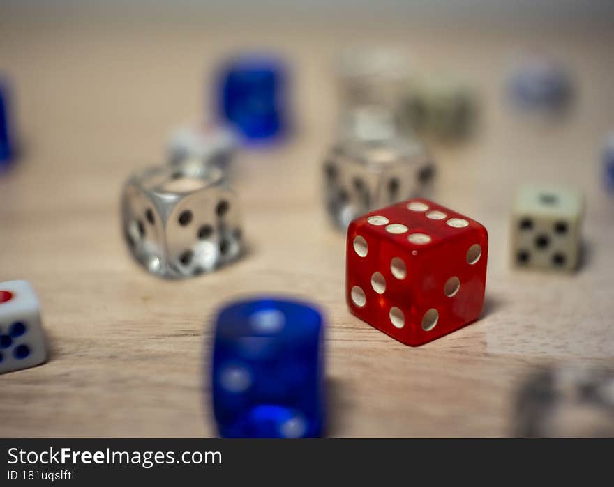 several color dice on a table focus on a red one