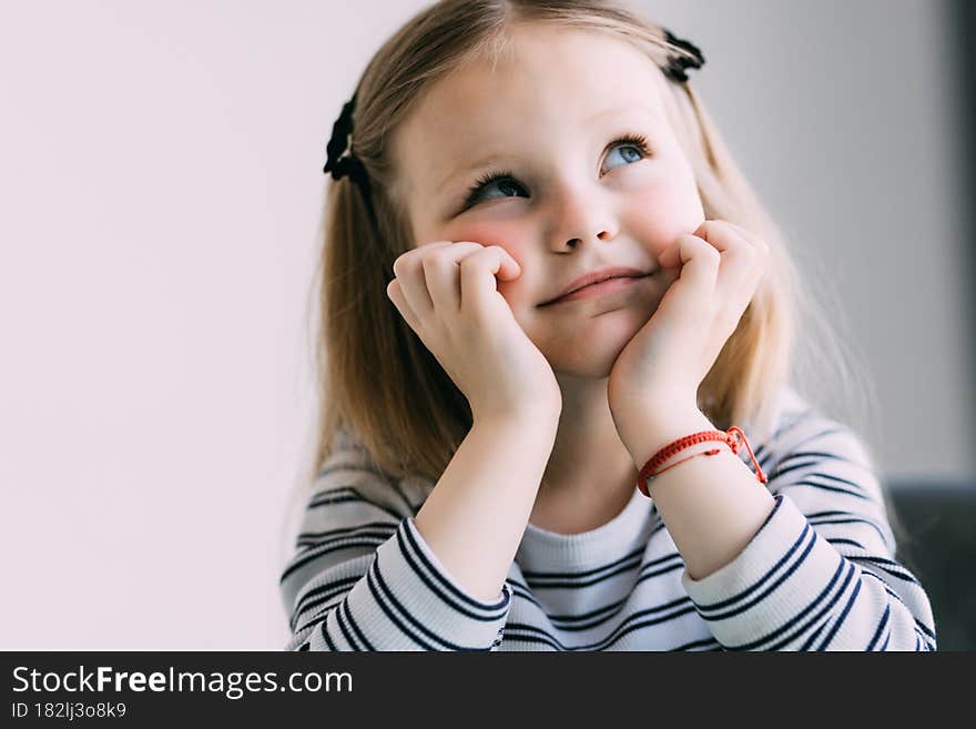 Portrait of cute thoughtful child girl. Dreaming people. Space for text