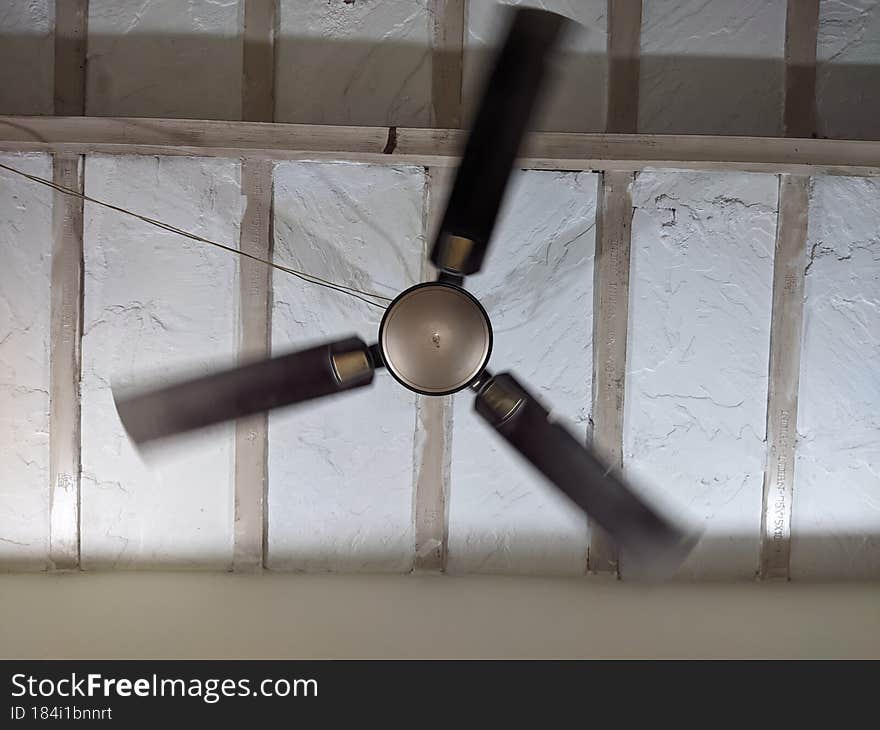 A ceiling fan moving with medium speed