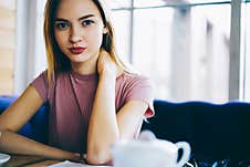 Youthful Hipster Girl In Casual Clothing Posing At Cafe Table Stock Image