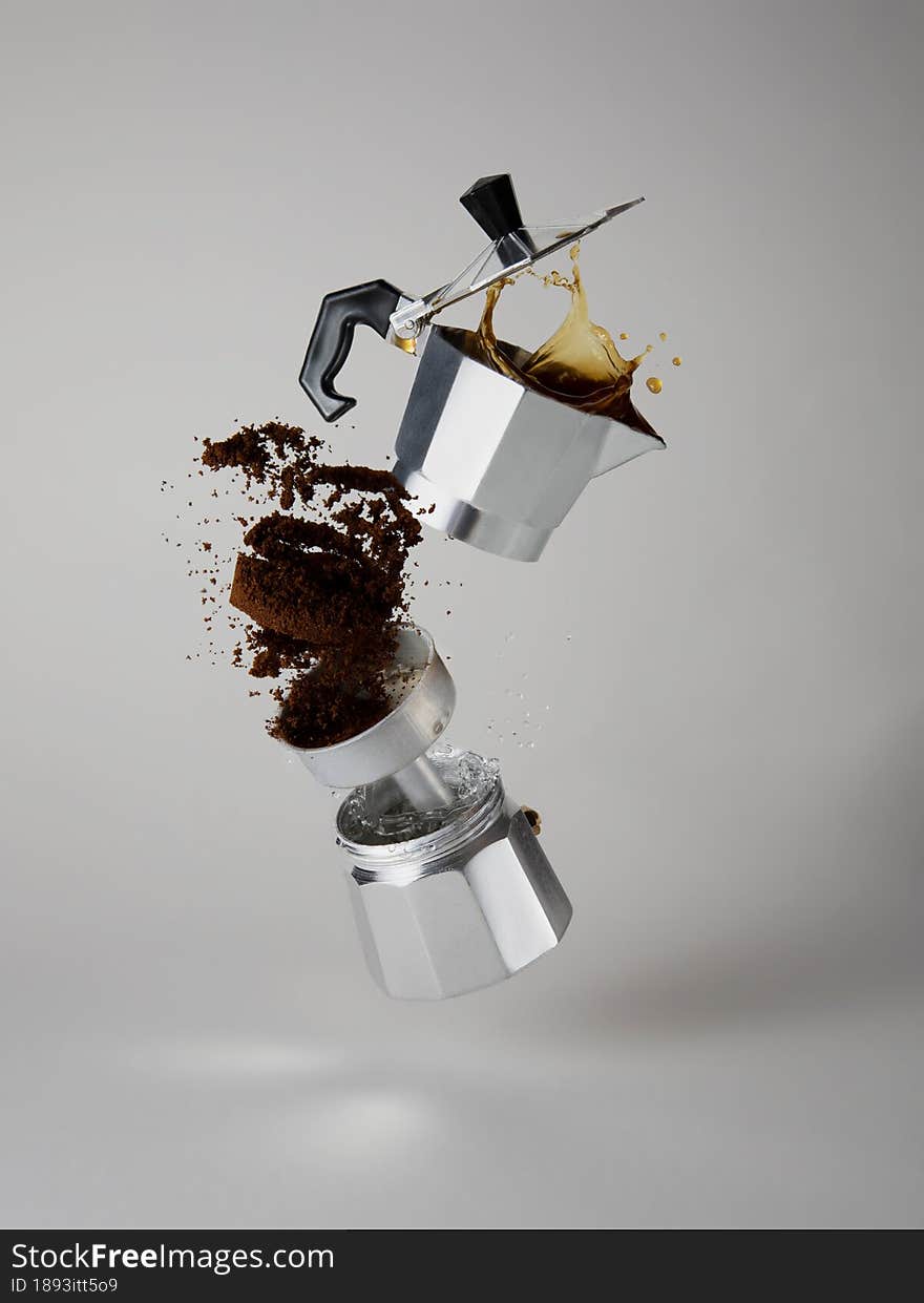 Geyser coffee maker with a splash of coffee and water. Ingredients of classic black coffee. Geyser coffee maker with a splash of coffee and water. Ingredients of classic black coffee
