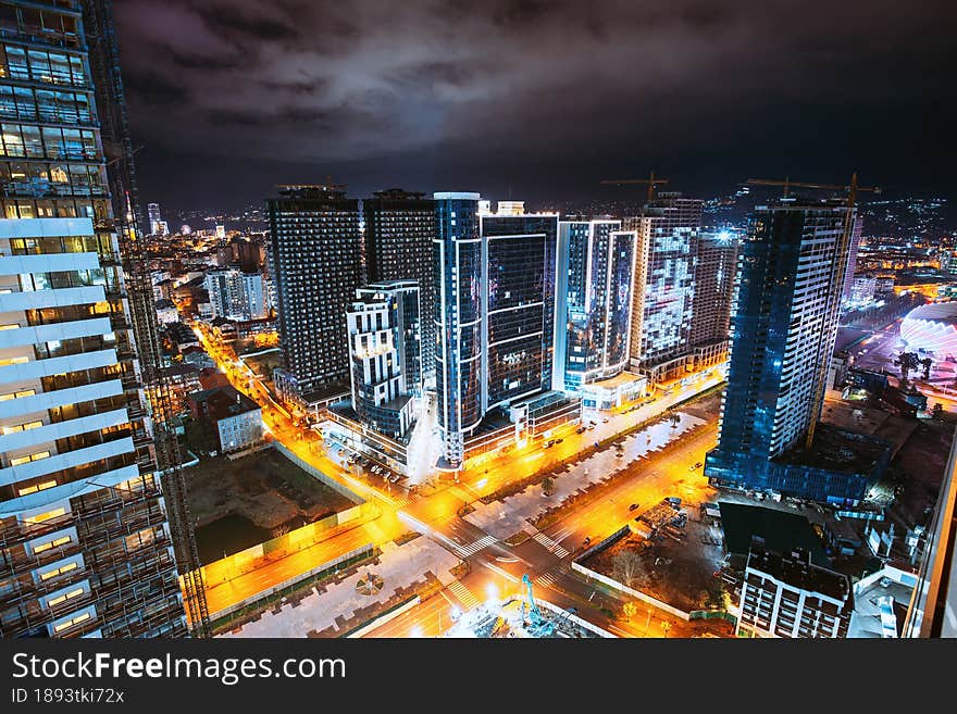 Street Night City Traffic and highrise houses . Elevated View Cityscape Skyline. Night Light Lighting. Industrial concept. Building industry