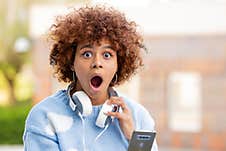 Girl With Mobile Phone And Expression Of Surprise Royalty Free Stock Images