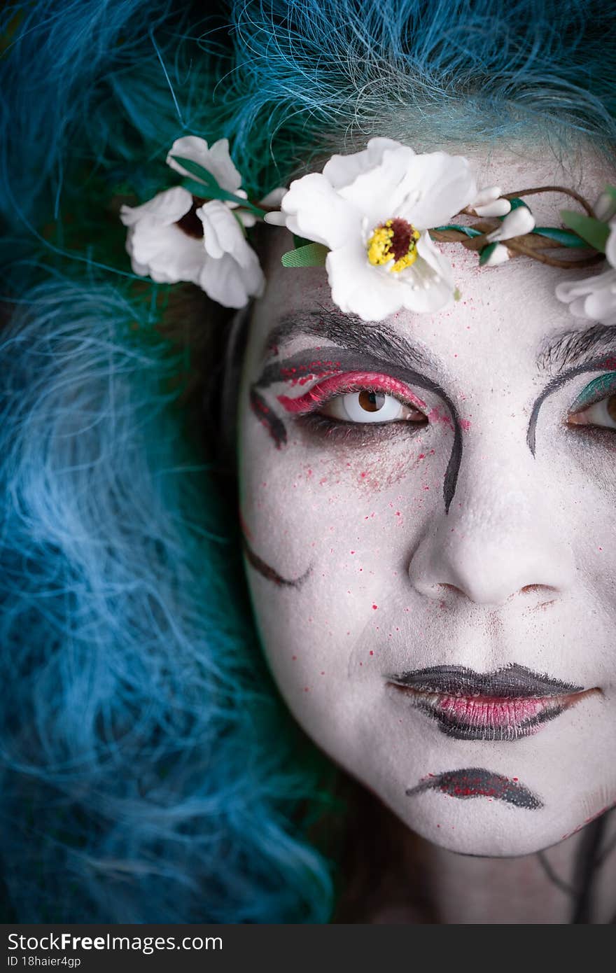 A girl in the image of a witch with green hair on black background