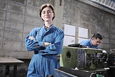 A Young White Female Industry Engineer Is Arms Crossed And Smiling In Factory Stock Photos