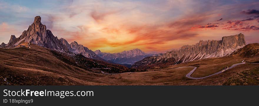 Italian Dolomites mountain Ra Gusela rock in front peaceful evening dusk panorama from Giau Pass. Picturesque climate, environment and weather concept sky background. Car models unrecognizable. Italian Dolomites mountain Ra Gusela rock in front peaceful evening dusk panorama from Giau Pass. Picturesque climate, environment and weather concept sky background. Car models unrecognizable