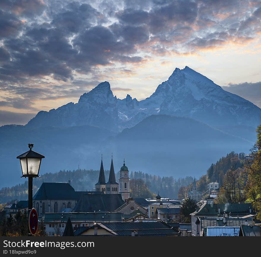 Autumn hazy day famous Bavarian prealps Berchtesgaden town and mount Watzmann silhouette in contra light, Germany. Autumn hazy day famous Bavarian prealps Berchtesgaden town and mount Watzmann silhouette in contra light, Germany