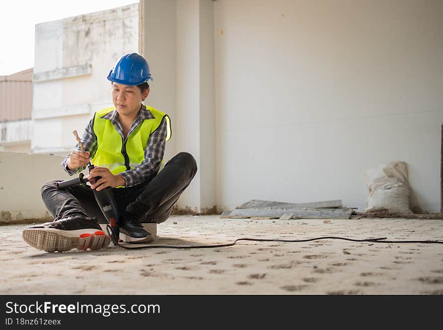 Construction worker Using an electric jackhammer to drill perforator equipment making holes before pouring the floor to be strong at construction site, Concept of worker and residential building