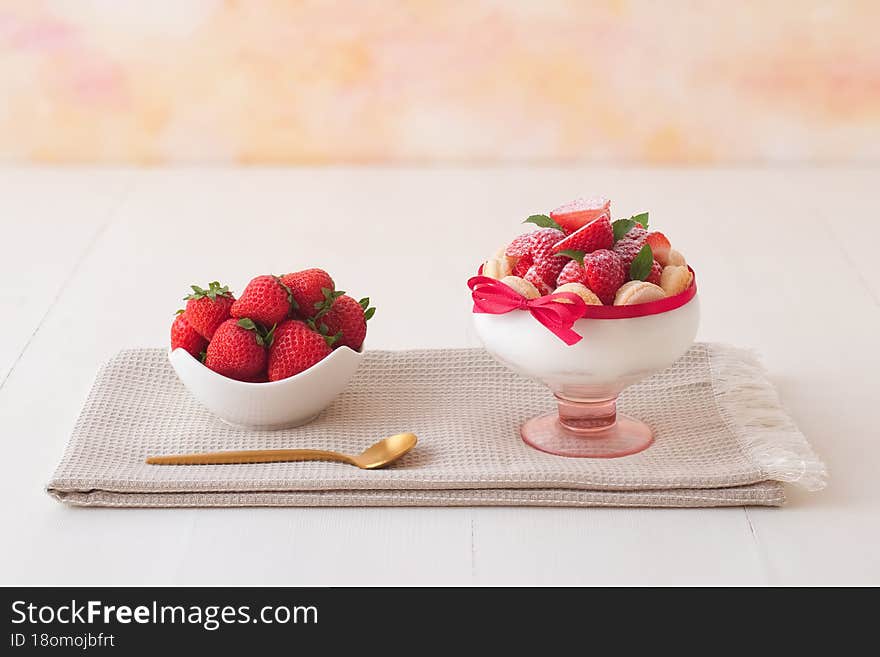 Charlotte, French dessert with strawberries tied up with a scarlet ribbon, easy and fast dessert made into a glass. Low angle view, no people. Charlotte, French dessert with strawberries tied up with a scarlet ribbon, easy and fast dessert made into a glass. Low angle view, no people