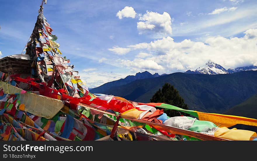 Looking at the Meili Snow Mountain in the distance through the prayer flags fluttering in the wind. Yun Nan China.