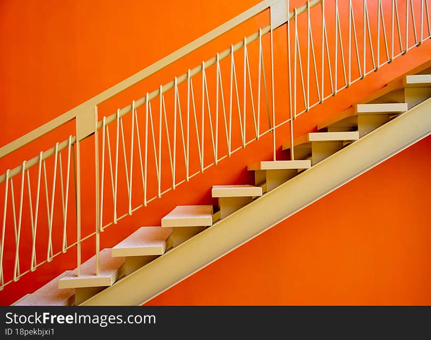 Metal stairs on the big orange wall.