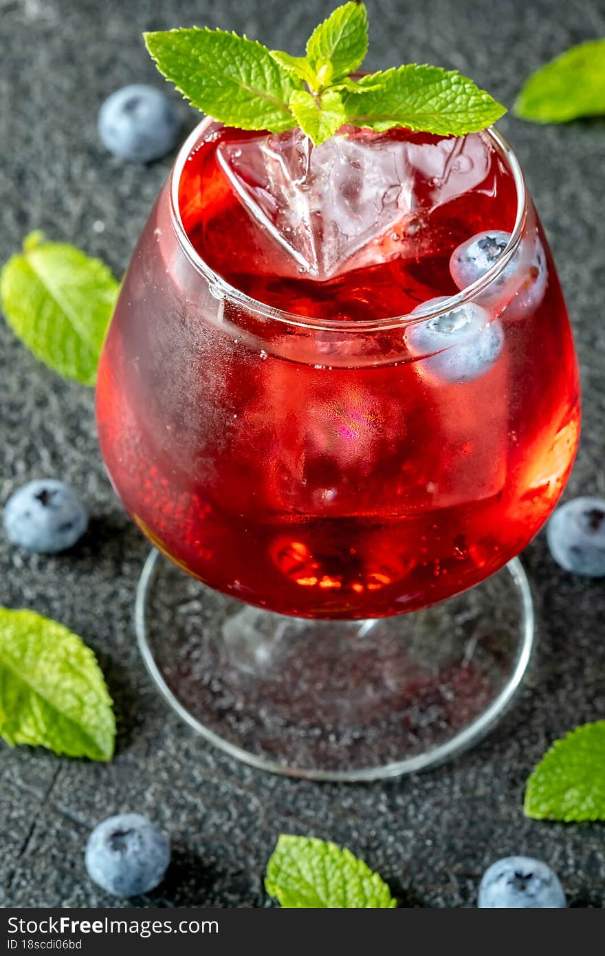 Glass of Blueberry Gin Smash cocktail garnished with mint
