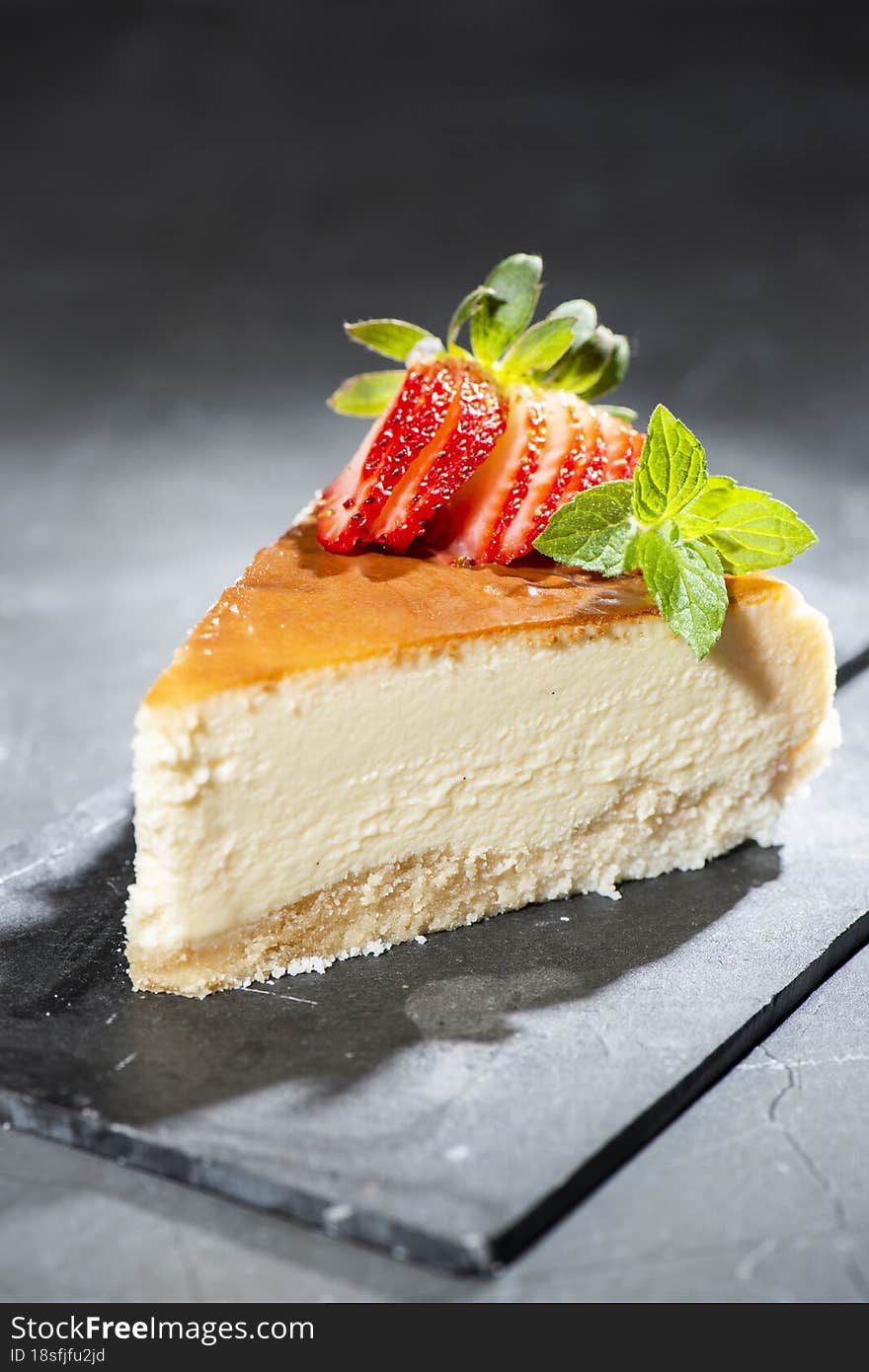 Homemade Traditional Cheesecake with fresh mint and sliced strawberries