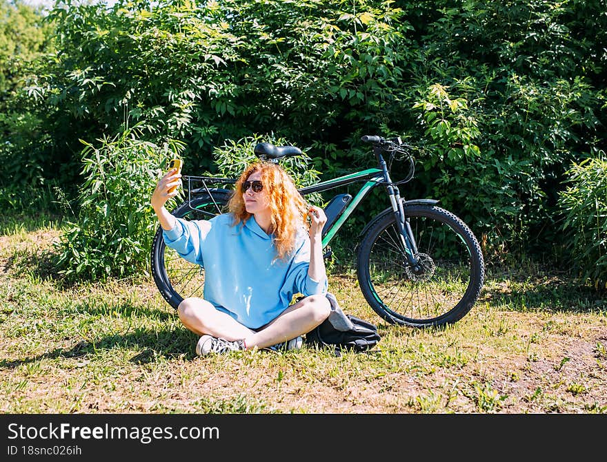 A young woman uses a modern electric bicycle for sports and outdoor recreation. E-bike - hybrid vehicle for the city