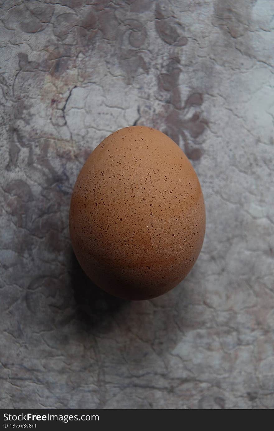 One chicken egg close up on a grunge surface.