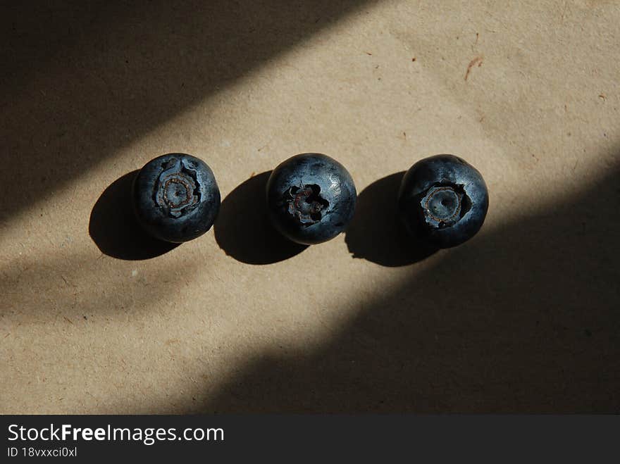 Three Blueberries In The Rays Of Light.