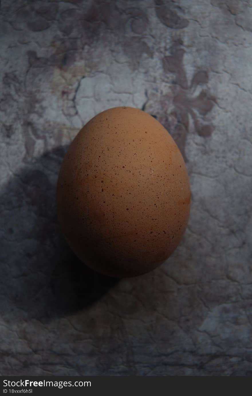 One chicken egg close up on a grunge surface.