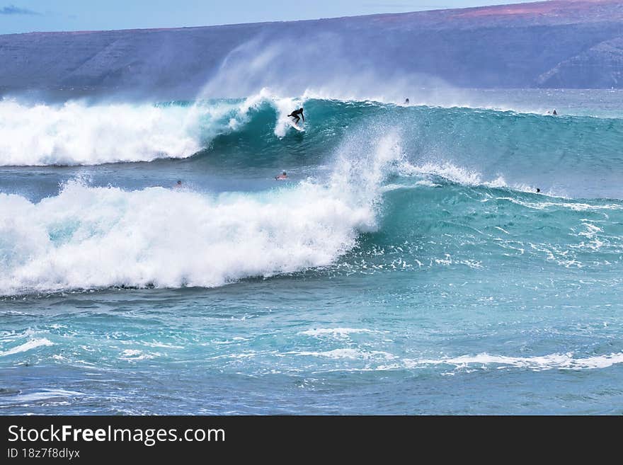 Young unrecognizable surfer pushing  through while riding a extreme surf ocean in Hawaii. Young unrecognizable surfer pushing  through while riding a extreme surf ocean in Hawaii.