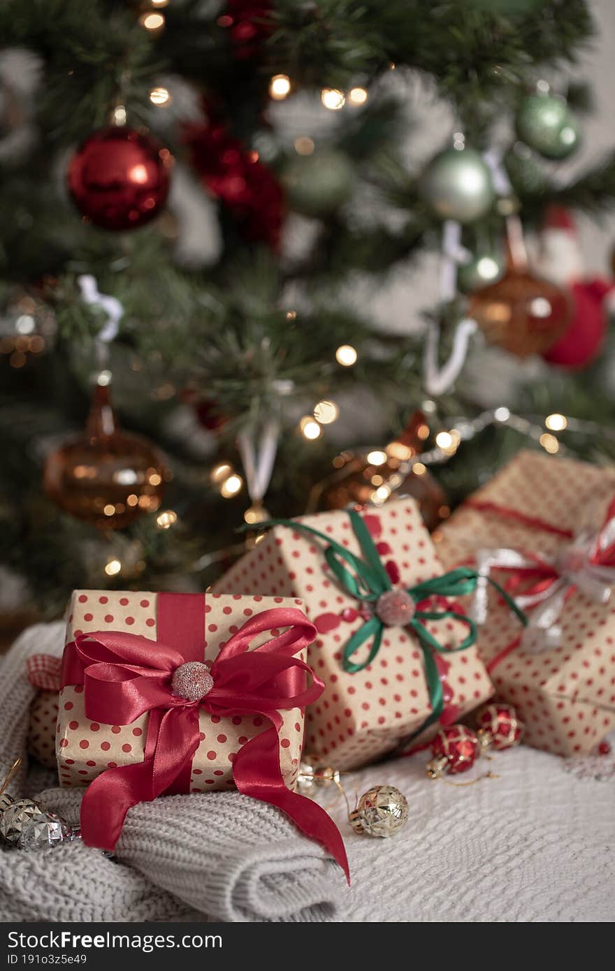 Festive gift boxes under the Christmas tree, close-up.