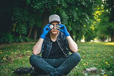 A Young Man Cleaning In The Forest, Portrait With Tin Cans. Royalty Free Stock Photography