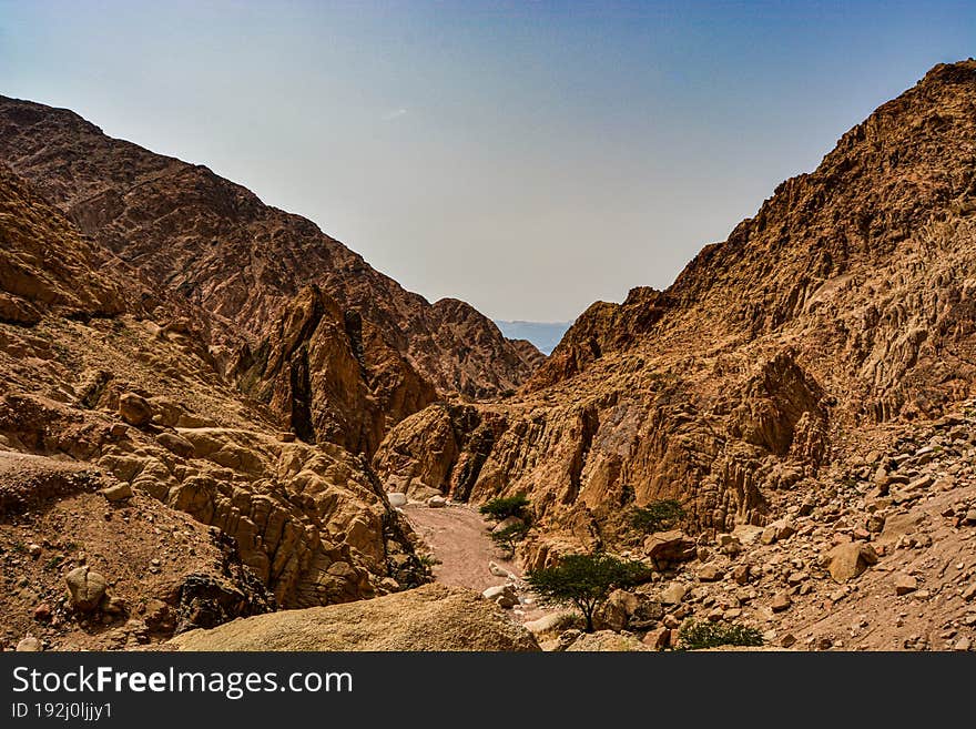 Picturesque road in the desert between the sandy mountains near the city of Aqaba in Jordan on the shore of the Red Sea