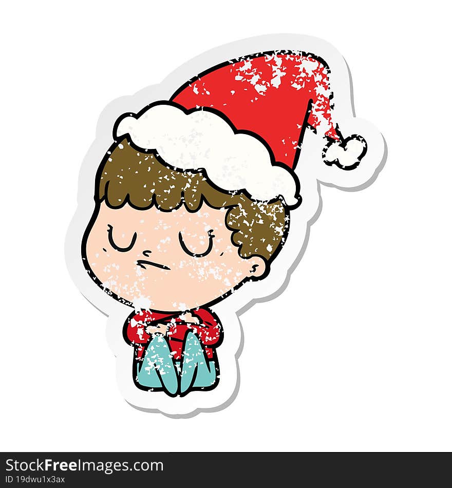 Distressed Sticker Cartoon Of A Grumpy Boy Wearing Santa Hat