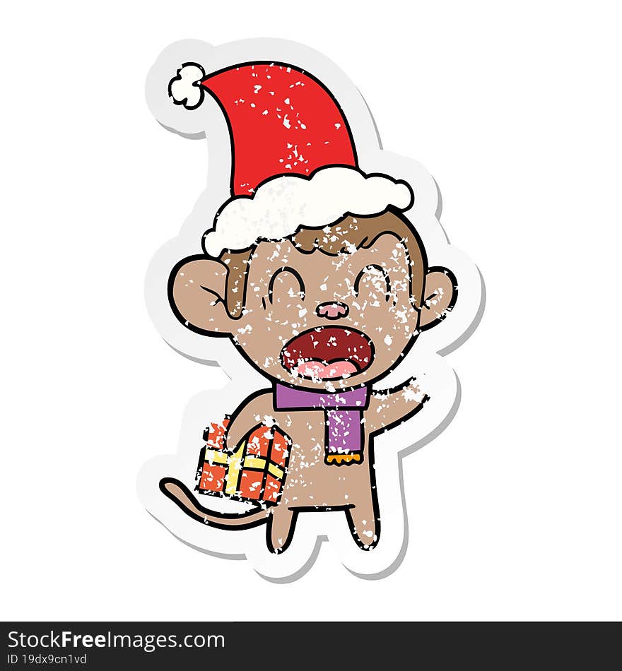 Shouting Distressed Sticker Cartoon Of A Monkey Carrying Christmas Gift Wearing Santa Hat