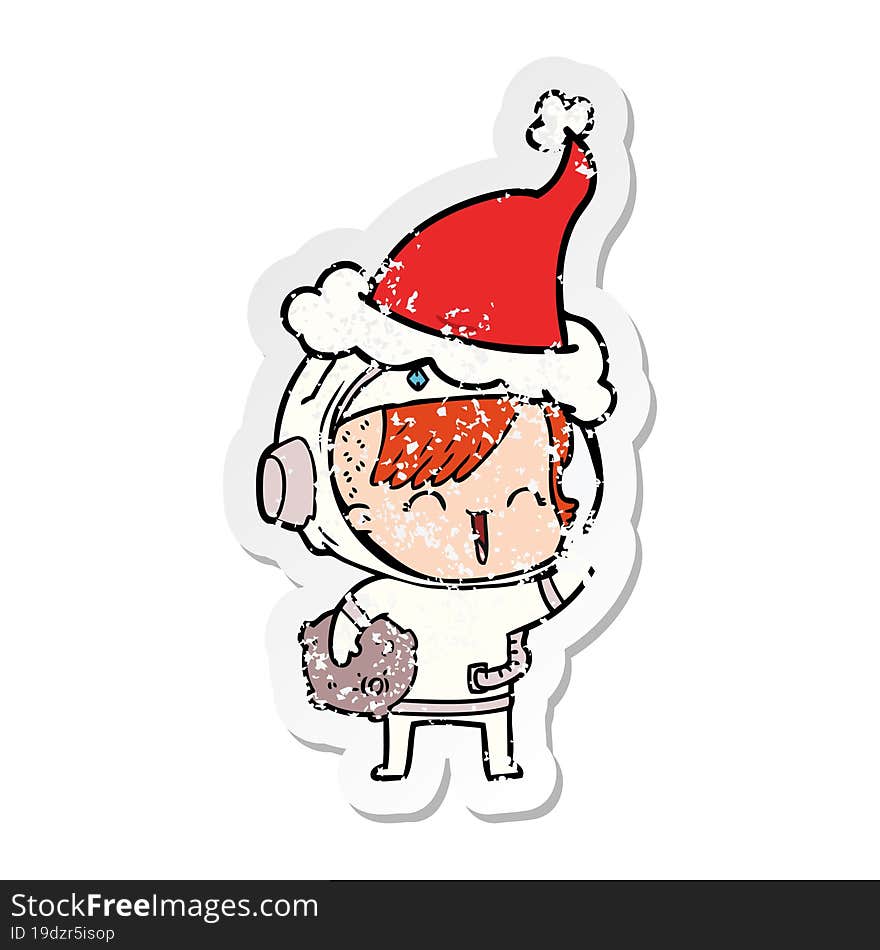 distressed sticker cartoon of a happy spacegirl holding moon rock wearing santa hat