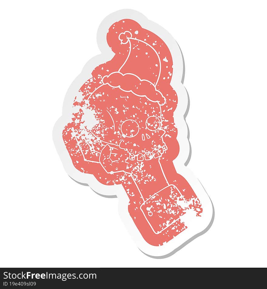 Cartoon Distressed Sticker Of A Hand Holding Skull Wearing Santa Hat