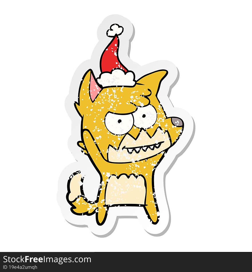 distressed sticker cartoon of a grinning fox wearing santa hat