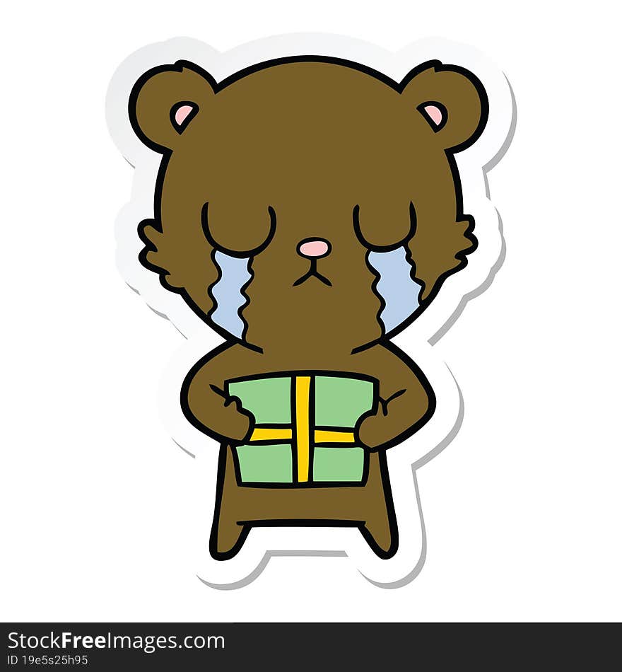 sticker of a crying cartoon bear with present