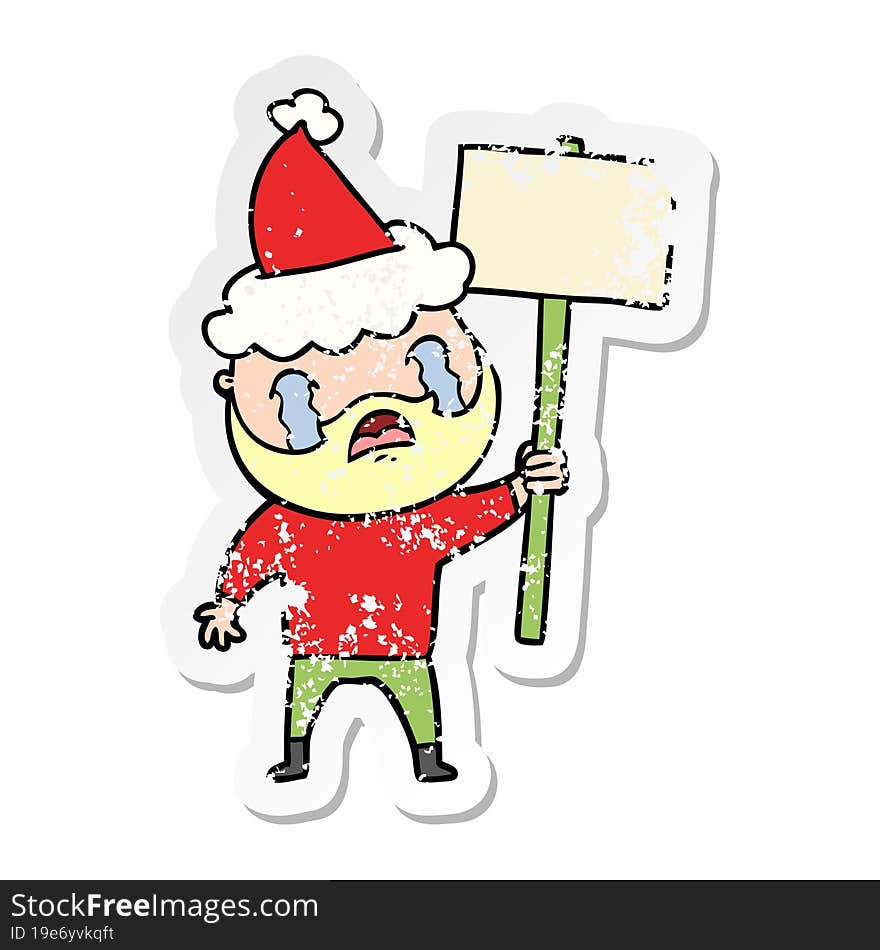 distressed sticker cartoon of a bearded protester crying wearing santa hat