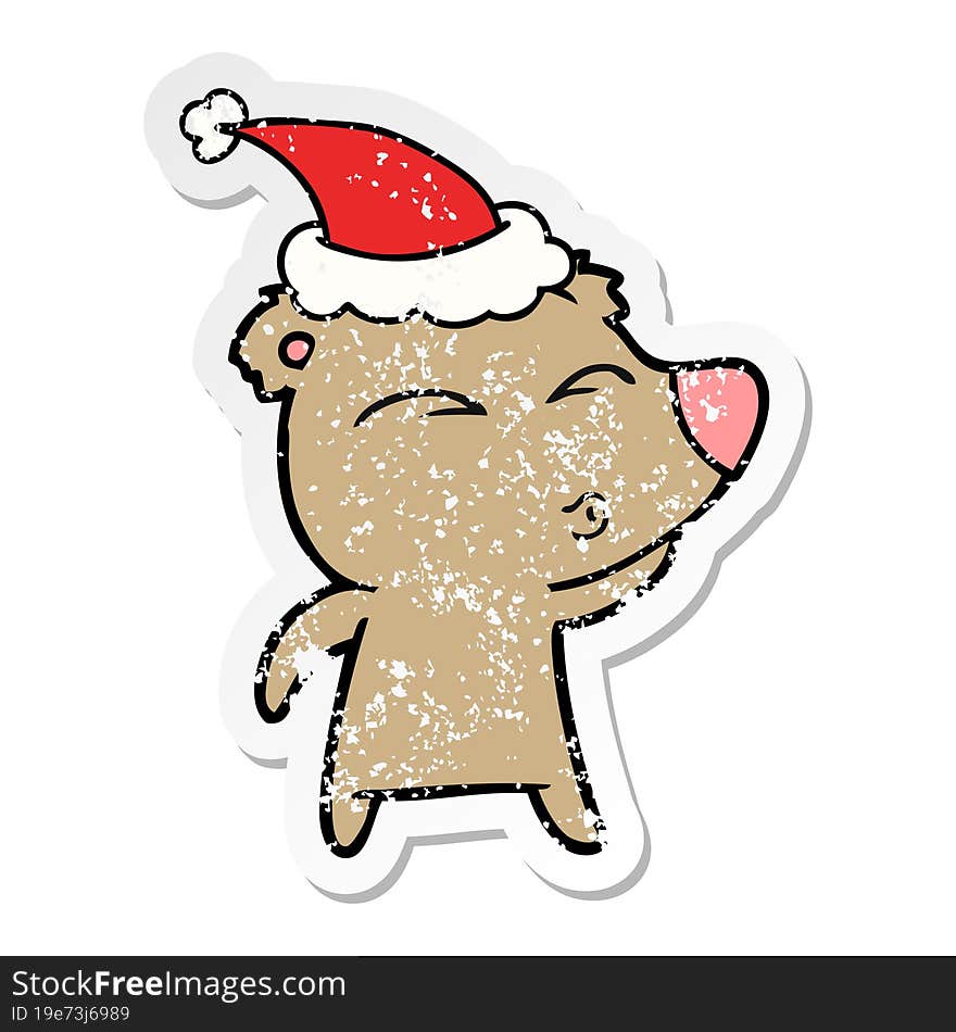 distressed sticker cartoon of a whistling bear wearing santa hat